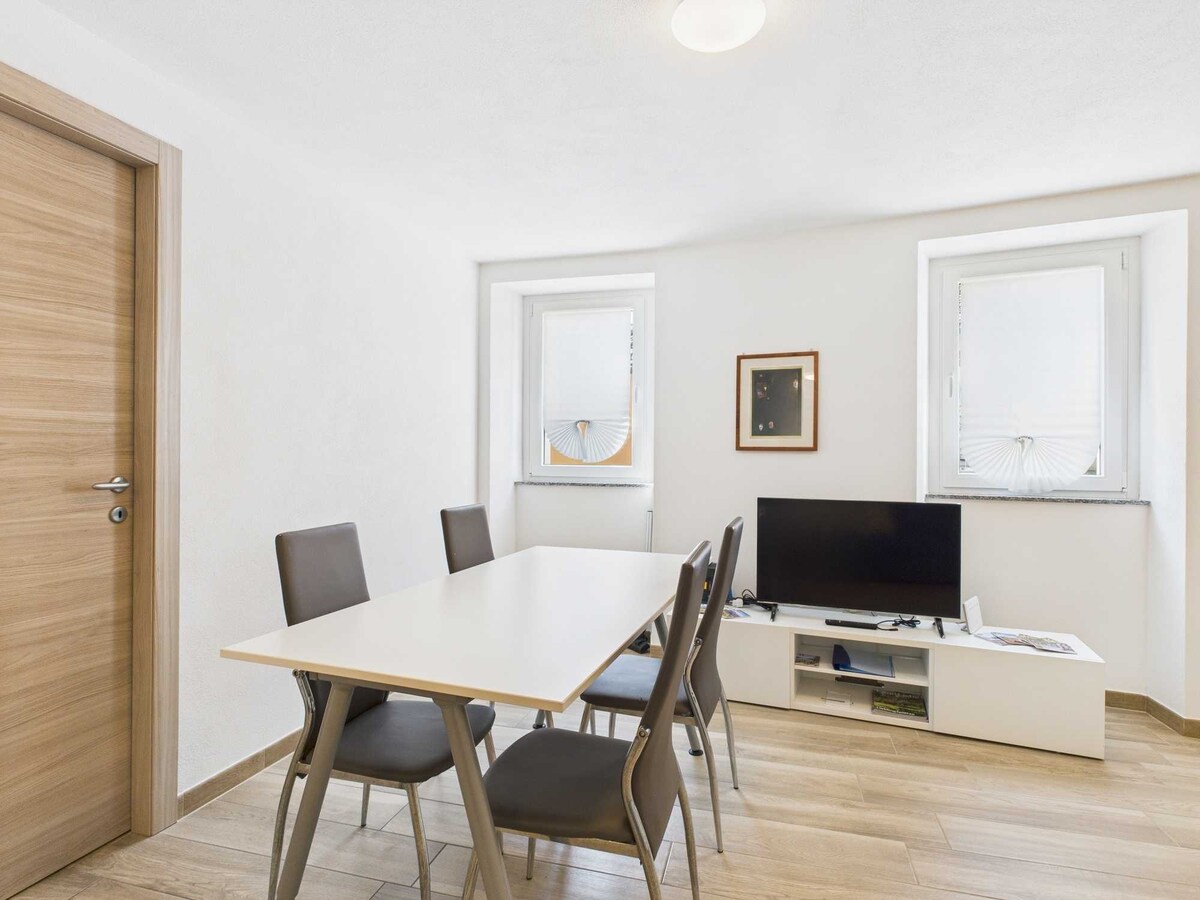 La zona pranzo con angolo TV è uno spazio accogliente e funzionale, ideale per mangiare e rilassarsi. Il tavolo da pranzo si combina perfettamente con l'area TV, creando un ambiente perfetto per momenti di convivialità e svago.