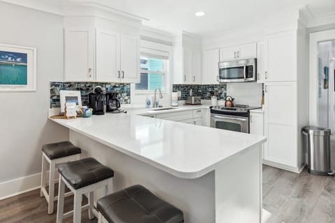 Huge kitchen with a breakfast bar, dining table, and an island w extra seating.