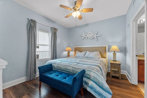 Spacious Retreat: The master bedroom offers a comfortable king bed, cozy bench seating, and convenient access to the private bath.