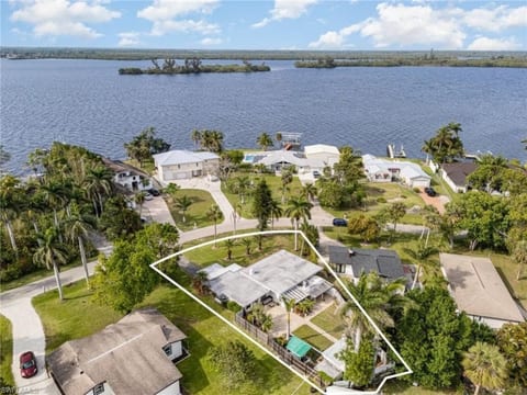 Exterior View: Stunning waterfront location with lush greenery and serene bay views awaits you!