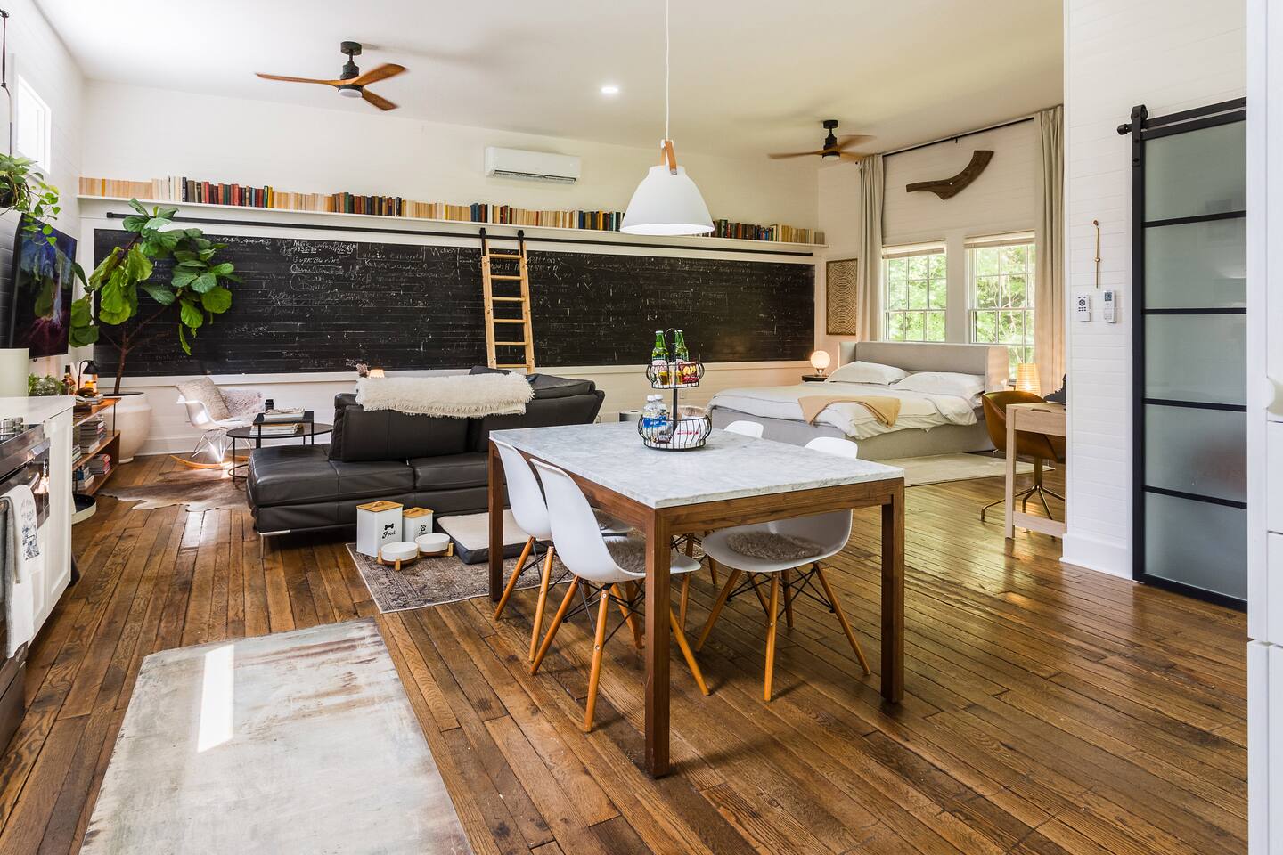 A stylish dining table for four anchors the open space, stocked with water, Ale-8-One, and other treats. It’s a perfect spot to gather, enjoy a casual meal, or sip a refreshing drink while taking in the schoolhouse’s airy, modern ambiance.