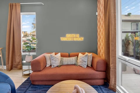 Living Room | Statement Neon Sign
Cozy living area with a velvet sofa, bold accent wall, gold curtains, and a glowing neon sign creating that perfect Nashville vibe.