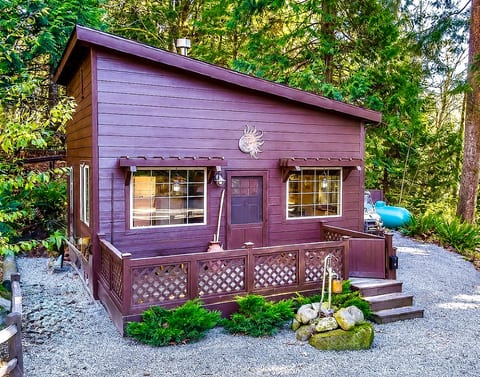 Cozy forest cabin with sunny porch, big windows, and tranquil setting