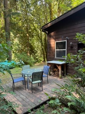 Private forest deck with outdoor dining beside the cozy cabin
