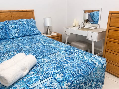 Comfortable queen bedroom with vanity area — practical for couples, solo travellers, or getting ready with ease.