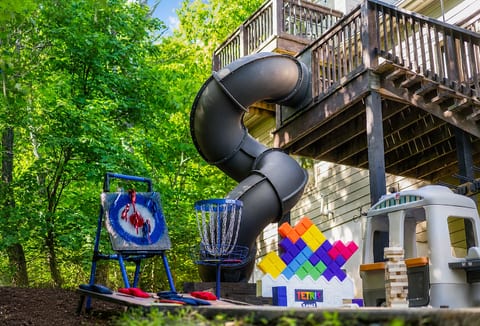 This is where downtime turns into memory-making: kids playing, adults laughing, and everyone drifting between games, the slide, and the mountain air.