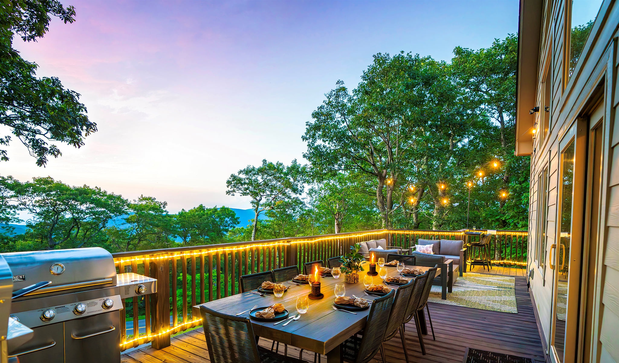 Twilight on the deck — mountains fading in the distance, wine glasses catching the glow of string lights, dinner sizzling on the grill. This is what gathering should feel like