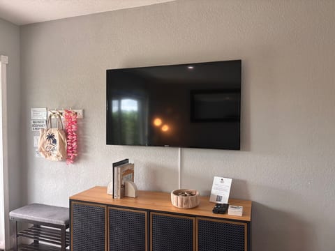 Large wall-mounted TV with stylish console and welcoming decor