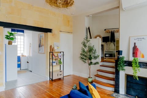 Bright, stylish lounge with loft steps, AC, plants, and peek to kitchen
