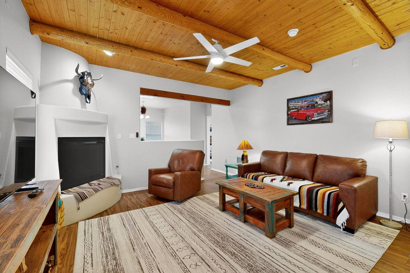 Kick back and relax in your cozy southwestern-style living room. Enjoy the rustic charm of the exposed log beams and warm up by the fireplace. Your perfect retreat awaits.


