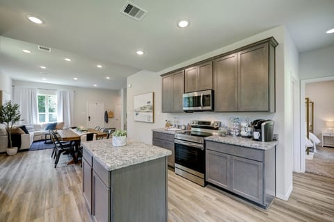 Bright, open-concept kitchen featuring wood-style flooring, ample cabinetry, and a handy breakfast island.
