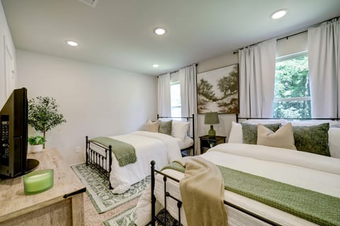 Two queen beds for guests, with plenty of pillows for comfort and blankets, and a Roku TV.