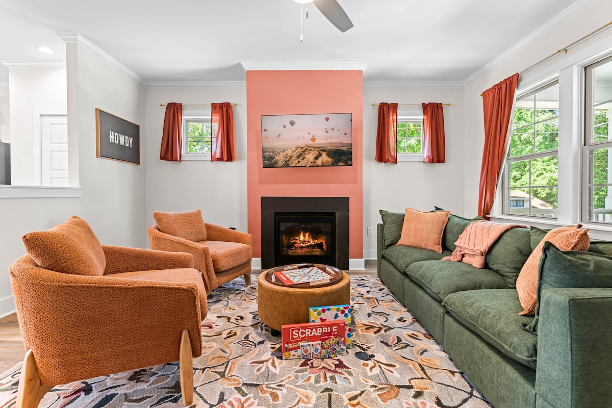 Relax in this cozy living room featuring plush seating, a warm fireplace, and a ceiling fan to keep things perfectly breezy.