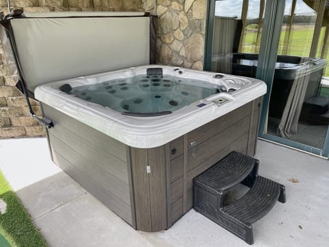 Private outdoor hot tub on the covered patio for year-round relaxation
