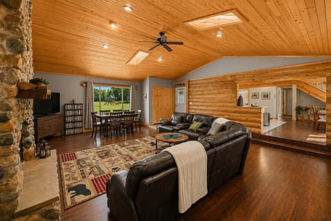 Spacious lodge-style great room with fireplace, dining area, and scenic views