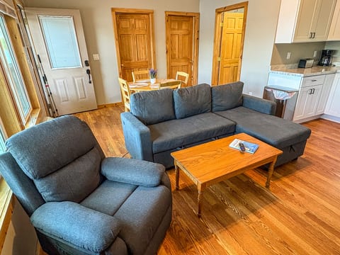 Cozy living area with sectional, recliner, dining nook, and bright natural light