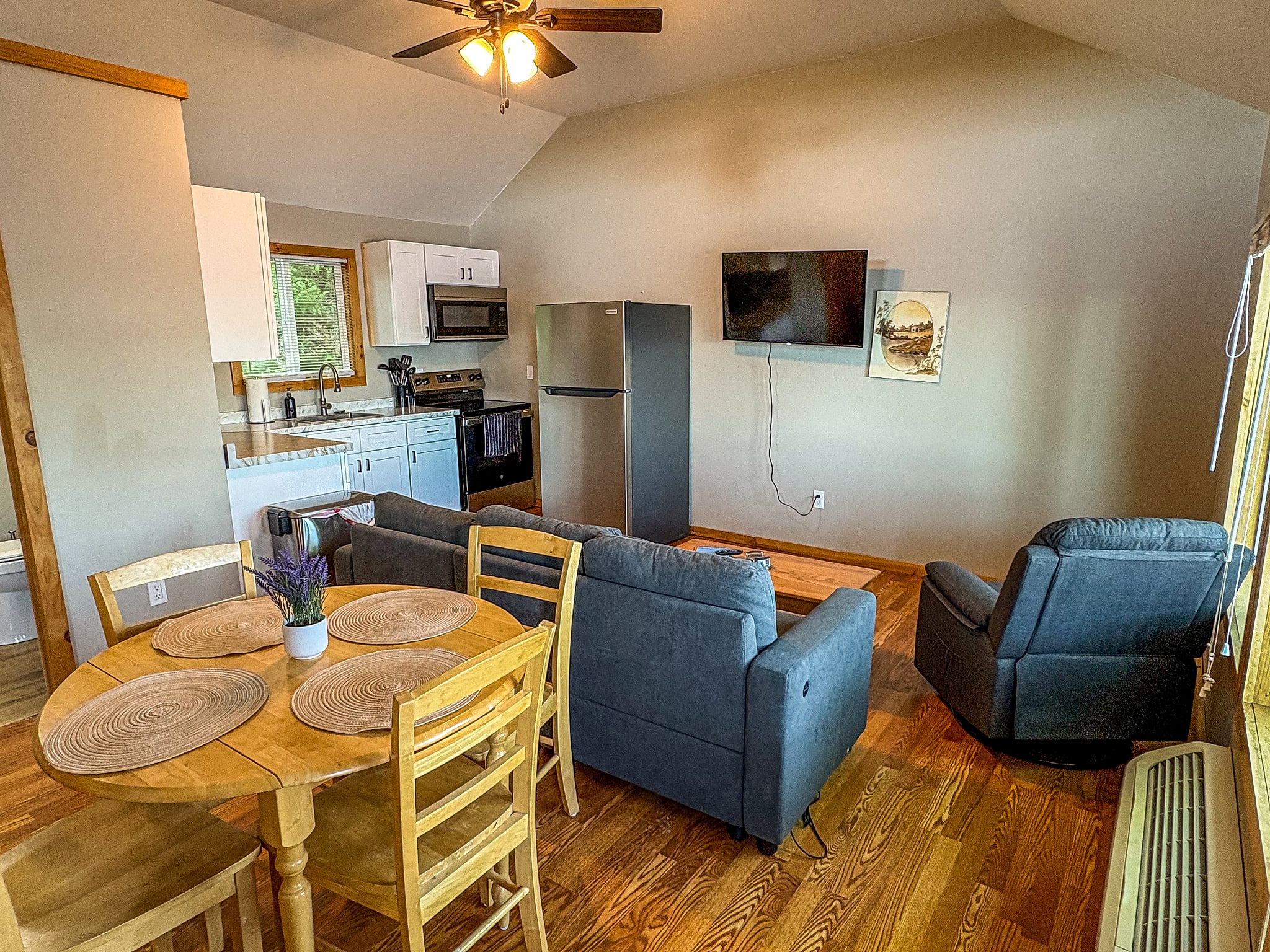 Cozy open-concept living space with kitchen, dining table, and TV