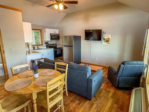 Cozy open-concept living space with kitchen, dining table, and TV