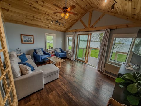 Cozy lakeview living room with vaulted ceilings and deck access