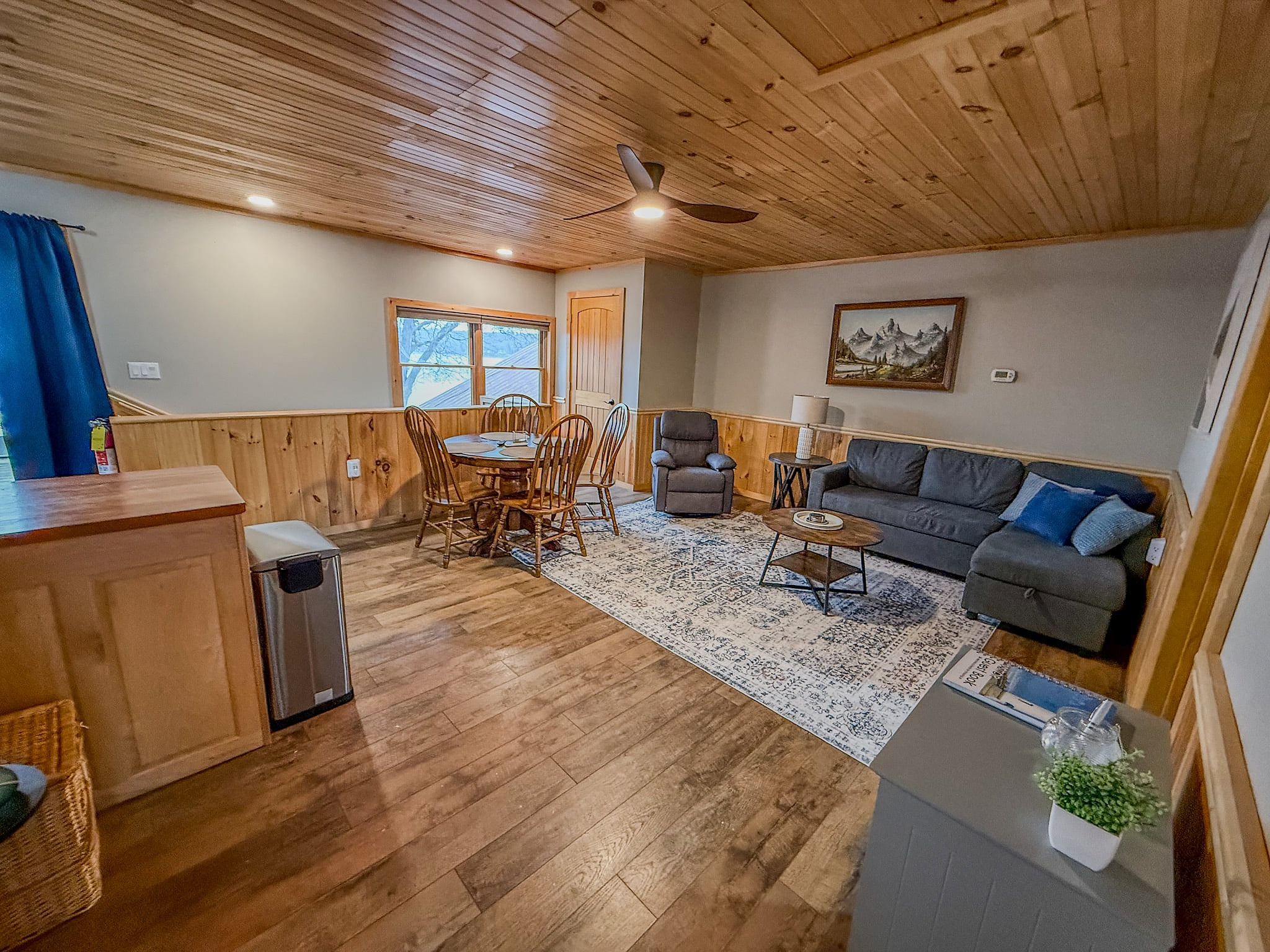 Warm wood-accent living area with sectional, recliner and dining nook