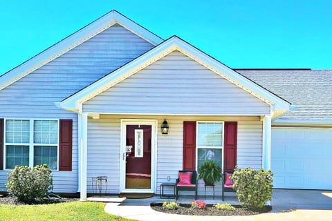 Welcome to A Southern Charm, a homey home. There is a front porch with seating and a table. 