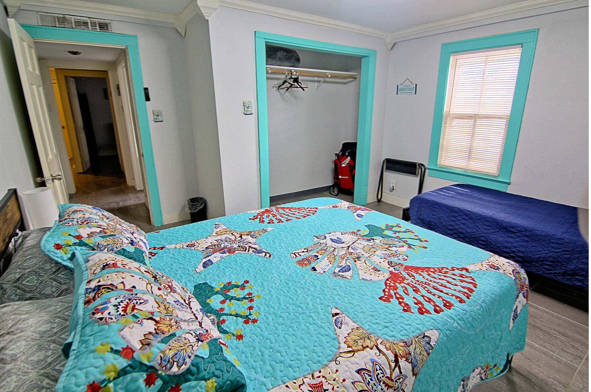 Bright bedroom with colorful decor, open closet, and extra twin bed