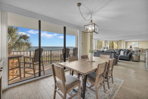 Bright coastal living room with panoramic Gulf views and direct balcony access