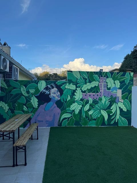 Outdoor Oasis: Vibrant mural and lush green space invite relaxation and creativity!