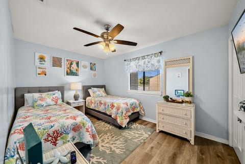 Guest Bedroom: Cheerful twin bedroom with coral reef bedding and beachy artwork