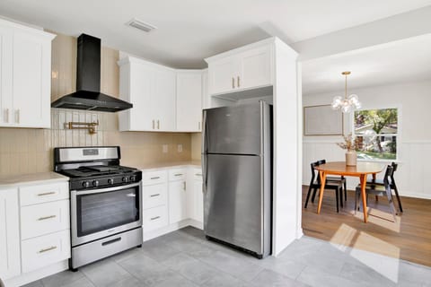 Fully equipped kitchen with stainless steel appliances, coffee bar, and dining space for family meals or work breaks.