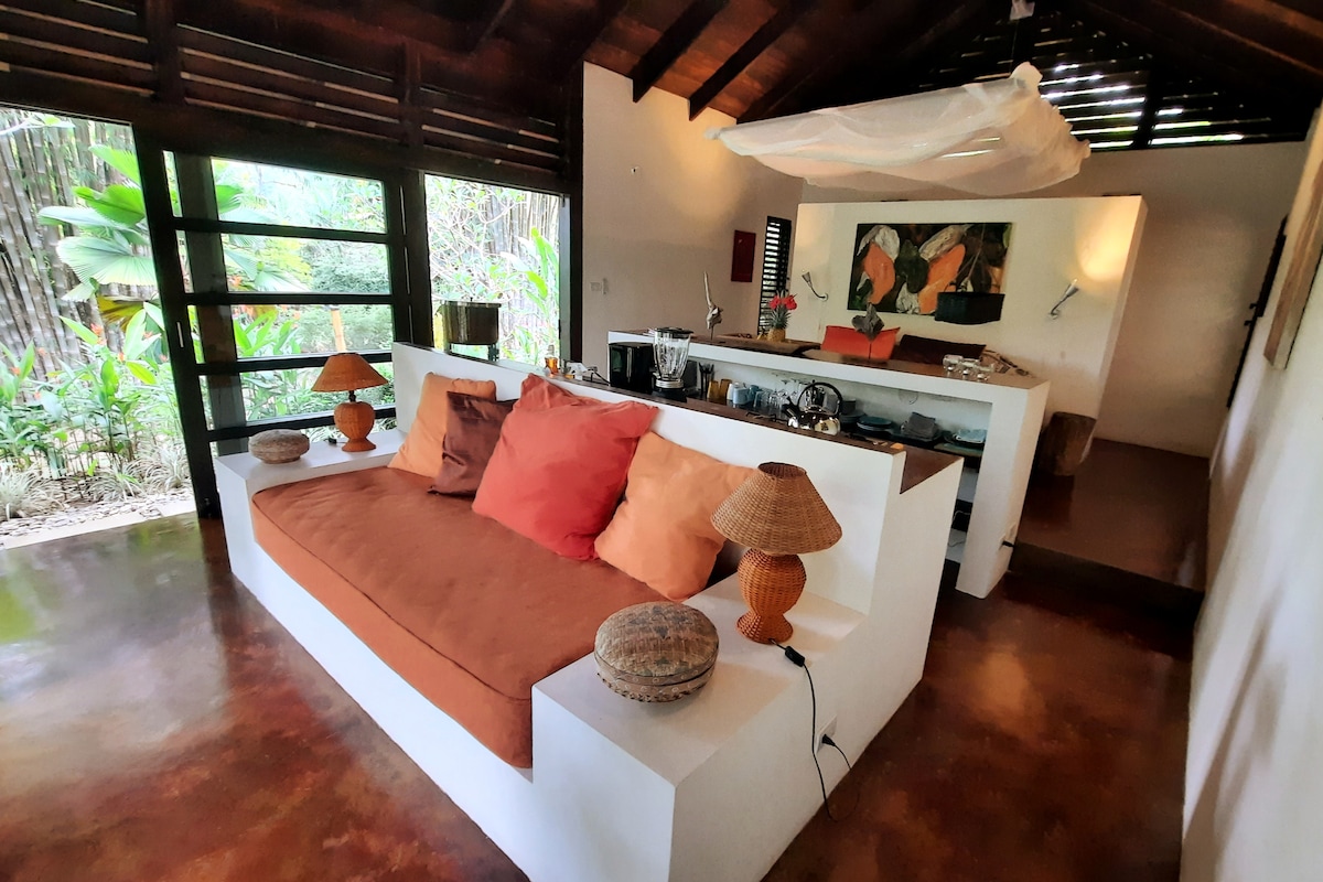 Living Room Day Bed Oasis: Immerse yourself in tropical vibes with vibrant decor and serene bamboo forest views!