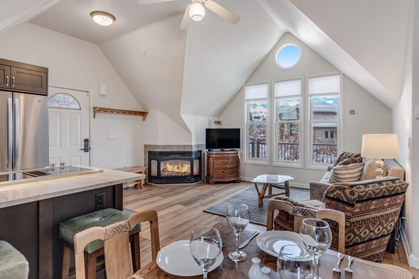 The dining area features a small table that seats 4, with additional bar seating