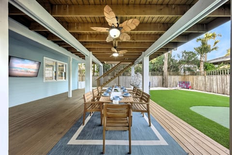 Resort style outdoor living: shaded dining, TV, fans, and plenty of room to play and relax