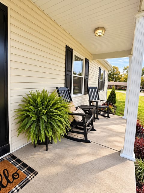 Rocking chairs on the front porch facing the road.
