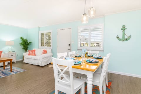 The dining area at OC Oasis blends coastal style with comfort — featuring a bright open layout that flows seamlessly from the kitchen to the living room.