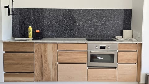 This kitchen includes an integrated dishwasher, fridge/freezer, oven/microwave combo, induction hob and plenty of utensils for cooking