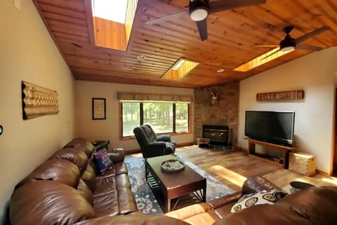 Escape to your cozy lake house retreat! Unwind by the fireplace in this inviting living room, perfect for relaxing after a day exploring. You'll love the comfort and charm of your lakeside getaway.