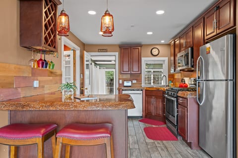Warm kitchen w/ granite, stainless, gas range & breakfast bar