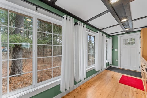 Bright window-lined entry with wooded views and warm rustic charm