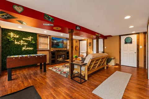 Fun game room with foosball, dartboard, fireplace, and cozy lounge seating