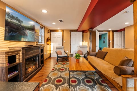 Cozy living room with fireplace, big TV, and warm rustic charm