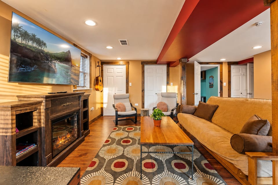 Cozy living room with fireplace, big TV, and warm rustic charm