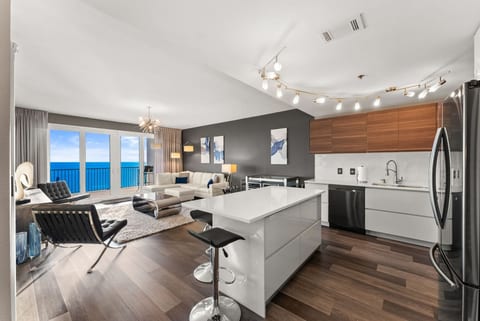 Living Room + Kitchen Ocean View – Spacious open-concept living area with floor-to-ceiling windows framing the Gulf.
