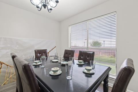 Sophisticated 6-seater table with room for four more in the kitchen—explore additional photos for a glimpse into stylish and spacious dining.