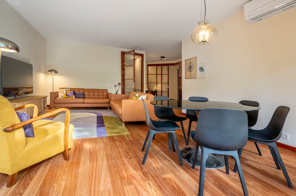 Bright and open living room with plenty of natural light, a warm wooden feel, and a mix of lounge, dining, and study spaces that make the room feel inviting and flexible