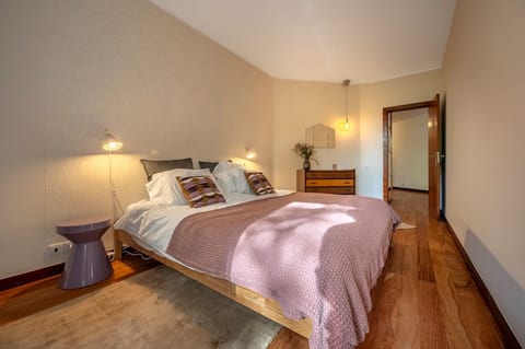 Bedroom 1: Elegant Retreat: King-size bed with warm hues, stylish decor, and ample sunlight for a serene escape!