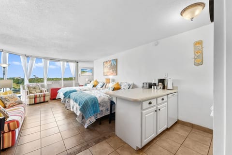 Spacious studio with two comfy beds and large windows for natural light