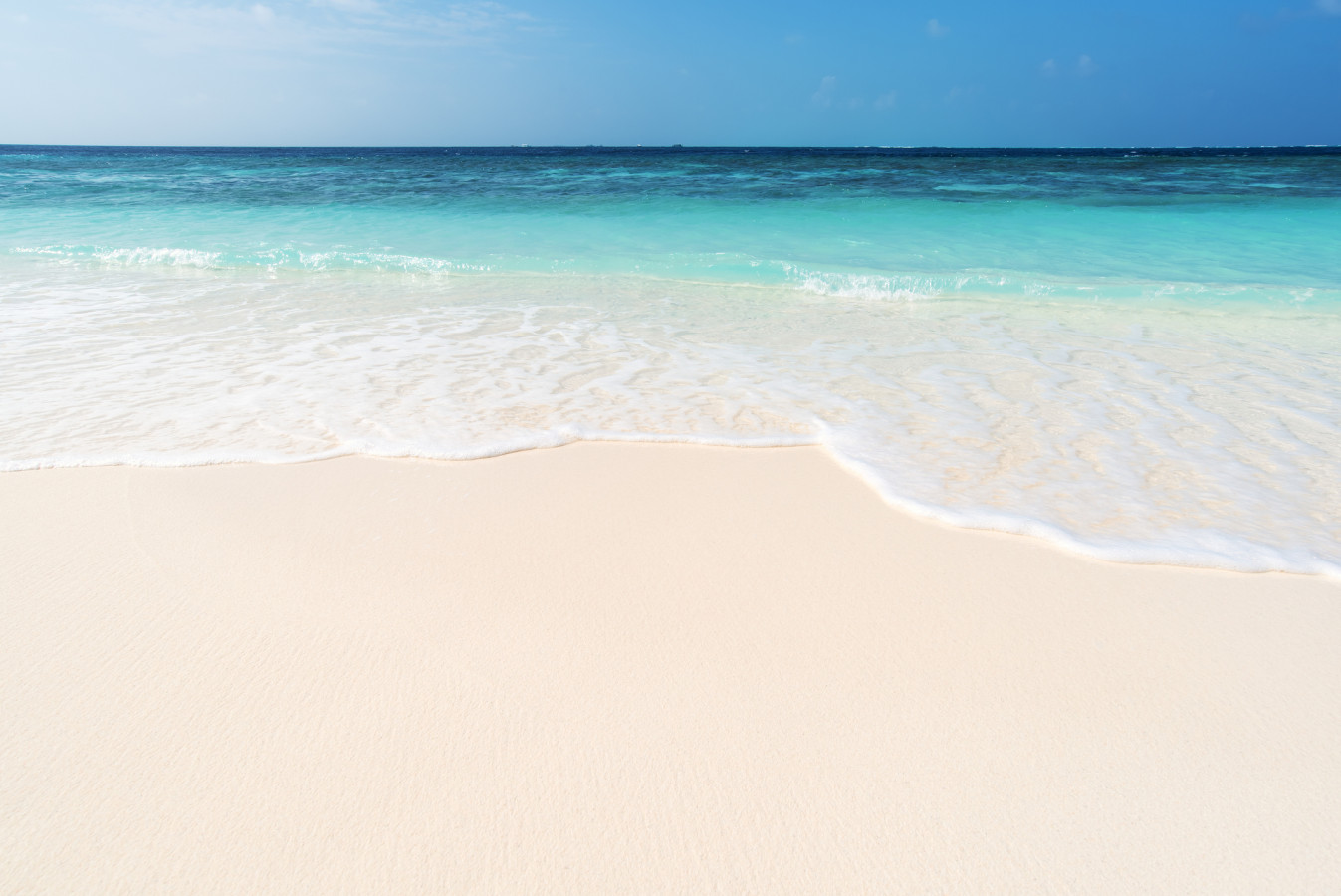 Gentle waves rolling onto soft sugar-white sand—perfect for relaxing beach days and morning walks.