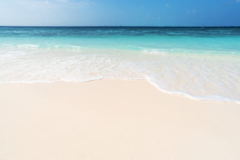 Gentle waves rolling onto soft sugar-white sand—perfect for relaxing beach days and morning walks.