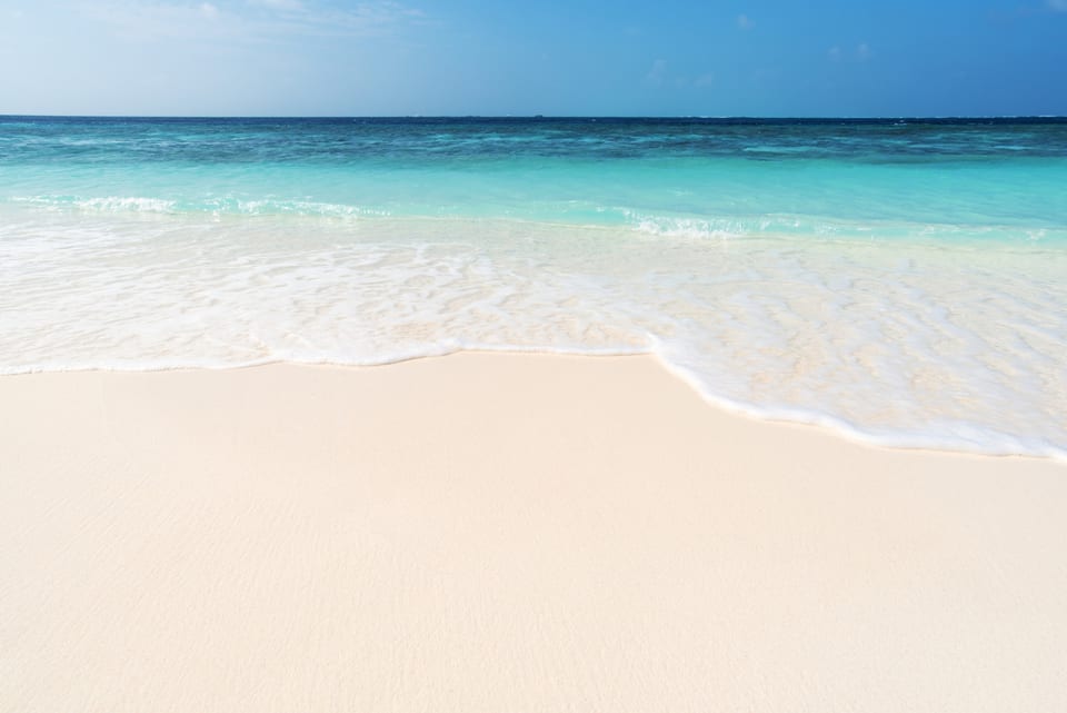 Gentle waves rolling onto soft sugar-white sand—perfect for relaxing beach days and morning walks.